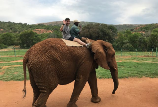 student riding an elephane
